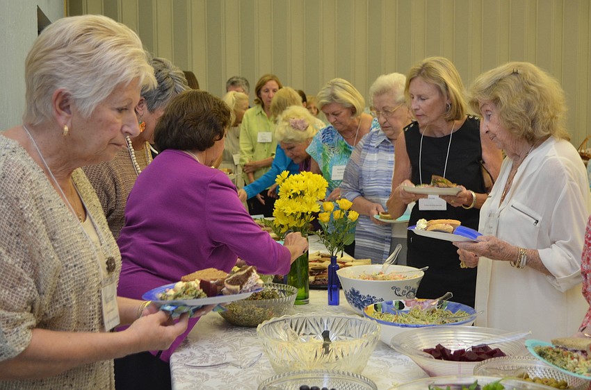 Members of the St. Mary Womenâ€™s Guild fill their plates in the buffet line at the Welcome Back luncheon.