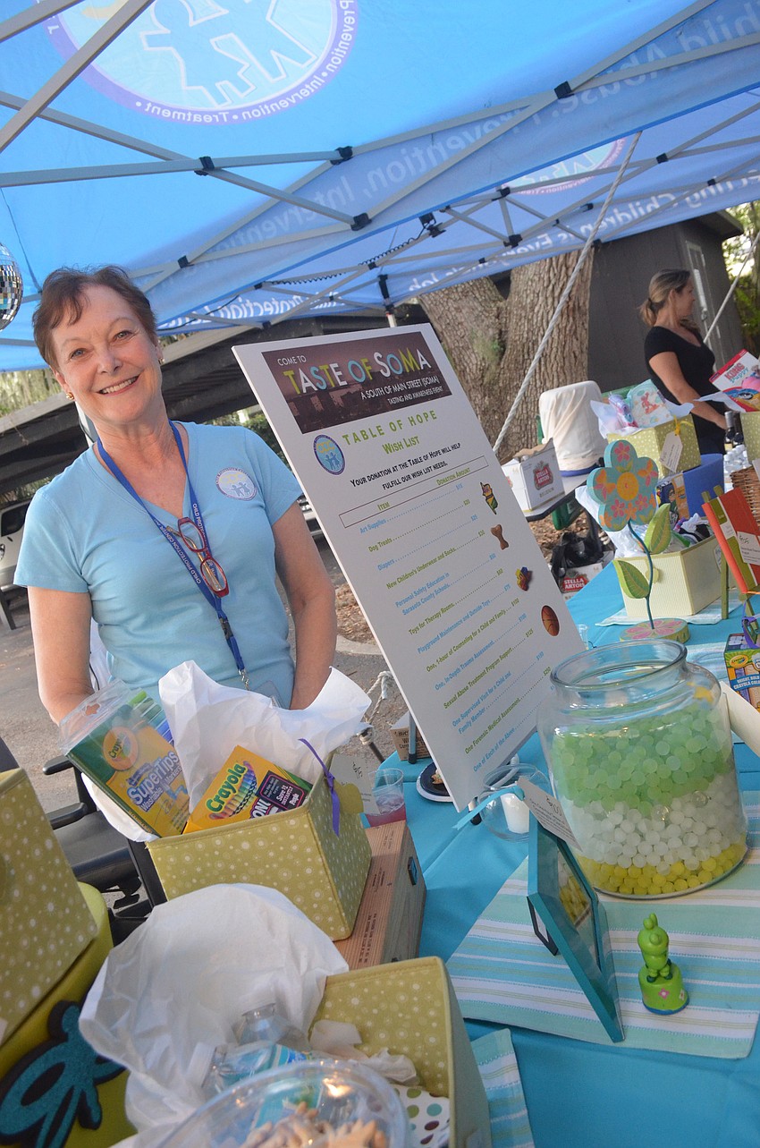 Child Protection Center administrative assistant Glenda Guthrie greets community members at the donation table.