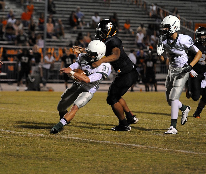 Sarasota defensive lineman Dominique Austin wraps up Lakewood Ranch running back James Jeffcoat.