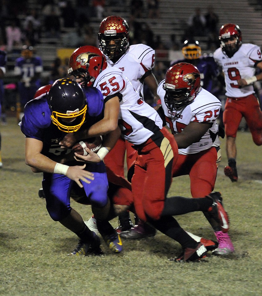 Cardinal Mooney defenders Vinny Conetta, Sean Morris and Charles Griffin tackle Booker fullback Cody DeSerio.