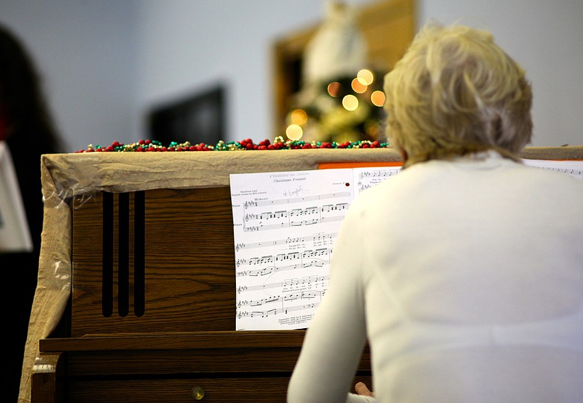 Lee Dougherty Ross plays the piano to accompany Michelle Giglioâ€™s singing.