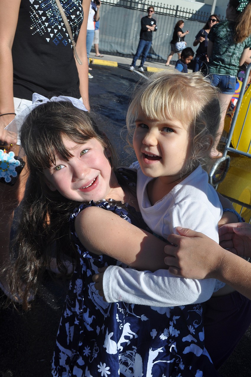 Anna Gotsman, 4, gives her friend Emma Bogucki, 3, a lift, while waiting in line.