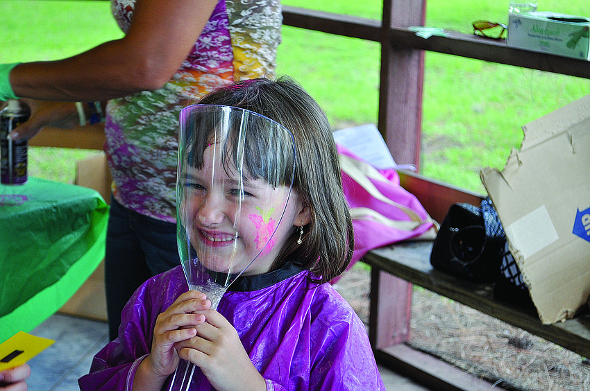Sarina McCormick gets her hair sprayed with glitter Sept. 15 at Girl Scout Camp Honi Hanta.