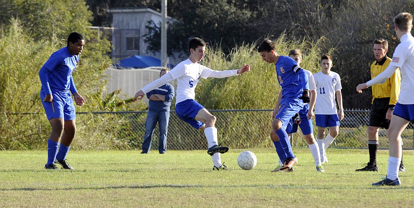 Sarasota Military Academyâ€™s Nicolas Guaton attempts to maneuver the ball around a Sarasota Christian defender during the first half of their non-district contest Jan. 7.