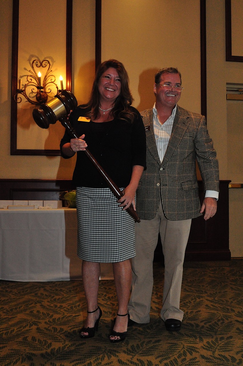 Annette Gueli accepts a ceremonial gavel from outgoing Chairman Tommy Klauber.