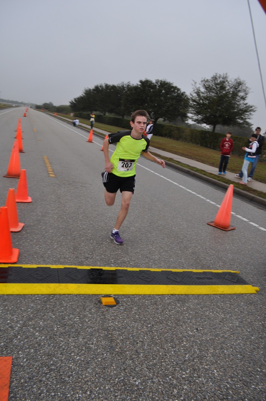 Nolan Middle School's Kyle Wray, 14, races across the finish line first, overall, at just more than 18 minutes.
