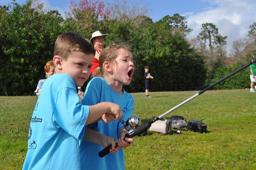 Nico Juliano helps his sister, Bella, reel in her second catch of the day.