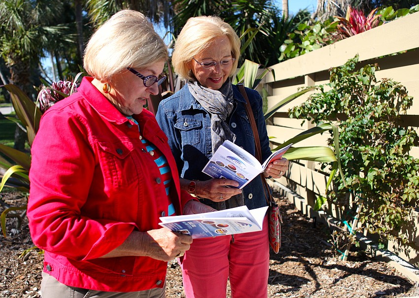 Kathy Alexis and Ginny Combs read about the Barberâ€™s home in their tour pamphlets.