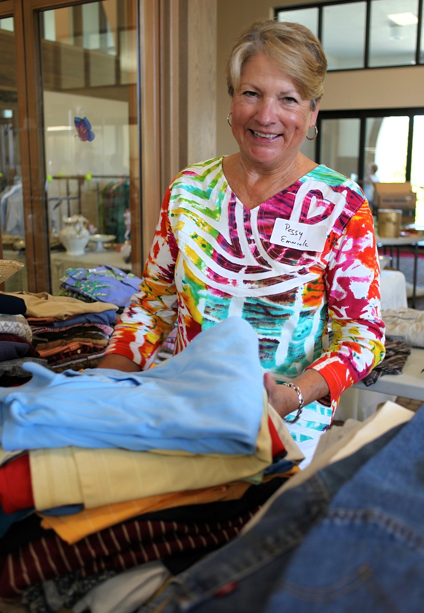 Peggy Emerick organizes the menâ€™s clothes.