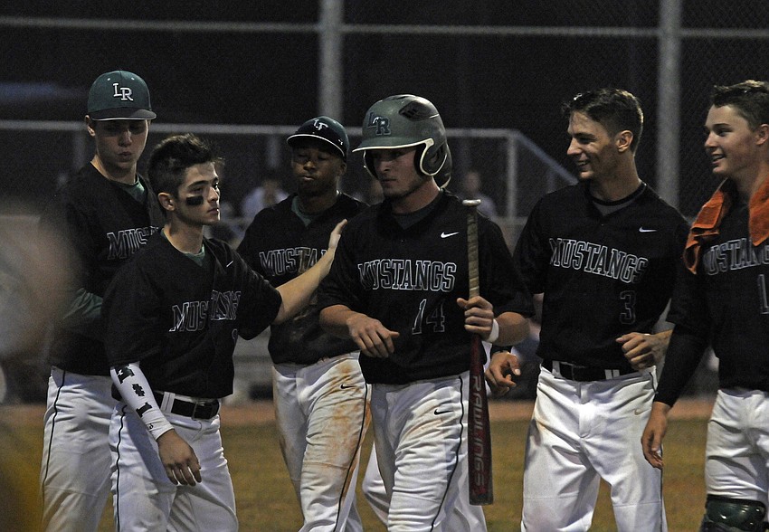 Lakewood Ranchâ€™s Justin Fischer is congratulated by his teammates after scoring the game tying run in the top of the third inning.