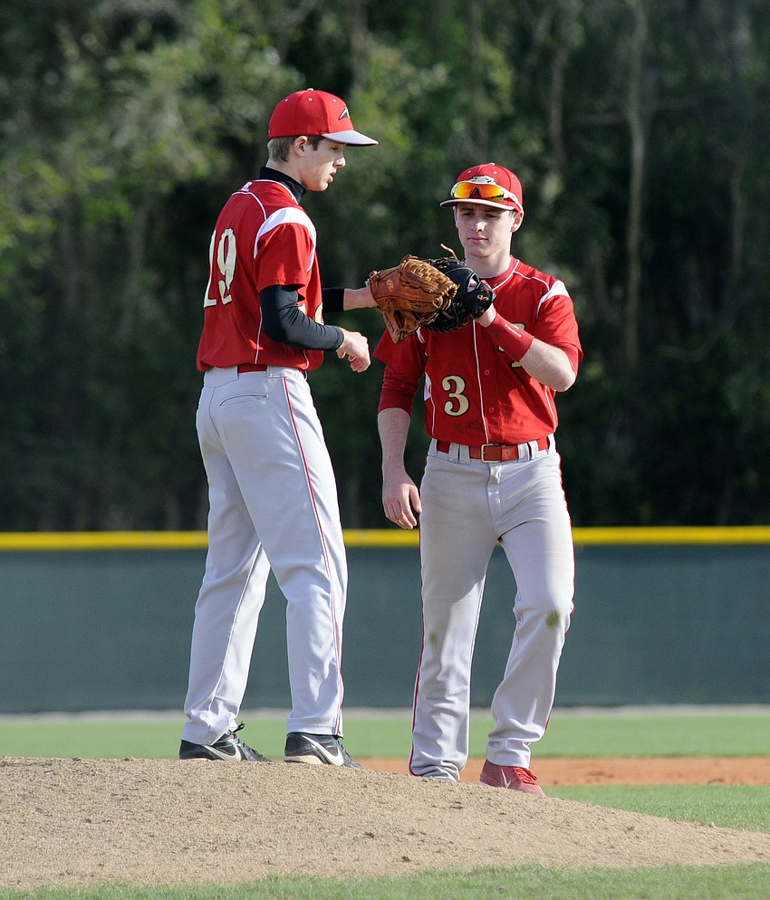 Cardinal Mooney senior Robby Shay, right, wishes pitcher Steven Varone luck before the start of the inning.