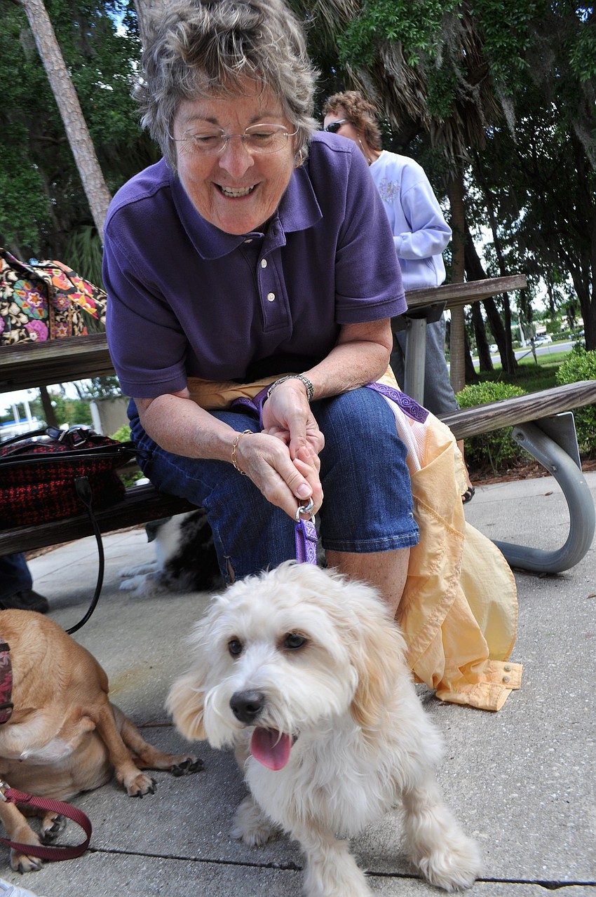 Diane Becher sits among friends with her dog, Gracie, after Gracie receives a blessing.