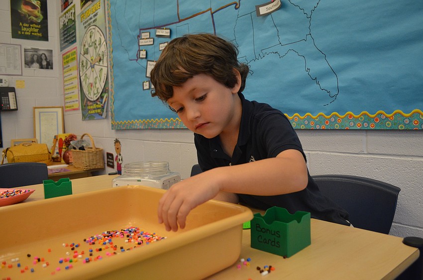 Max Mahler plays with beads after stuffing his doll.