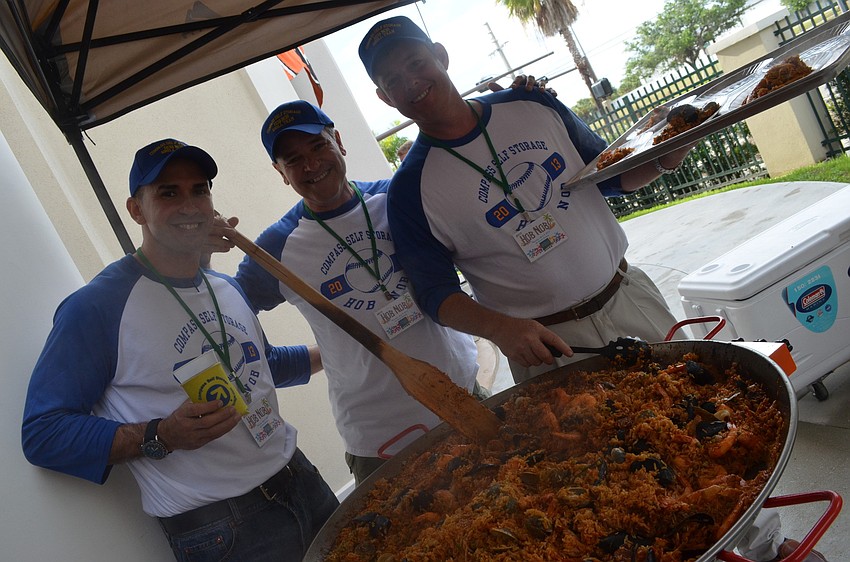 John Kibbe, Gus Maragliano and Scott Barrett of Compass Self Storage passed out paella to the crowd.