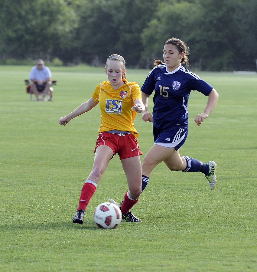 Clearwater Chargers Elite midfielder Delaney Tyl attempts to dribble the ball around a West Side Lady Eagles defender.