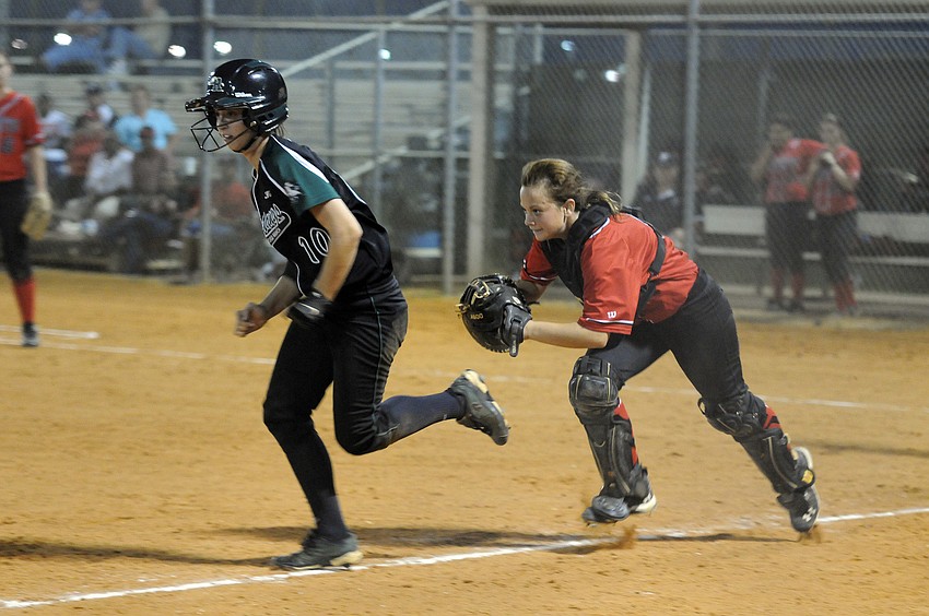 Lakewood Ranch senior Taylor Newton attempts to outrun Palmettoâ€™s catcher and get back to third base.