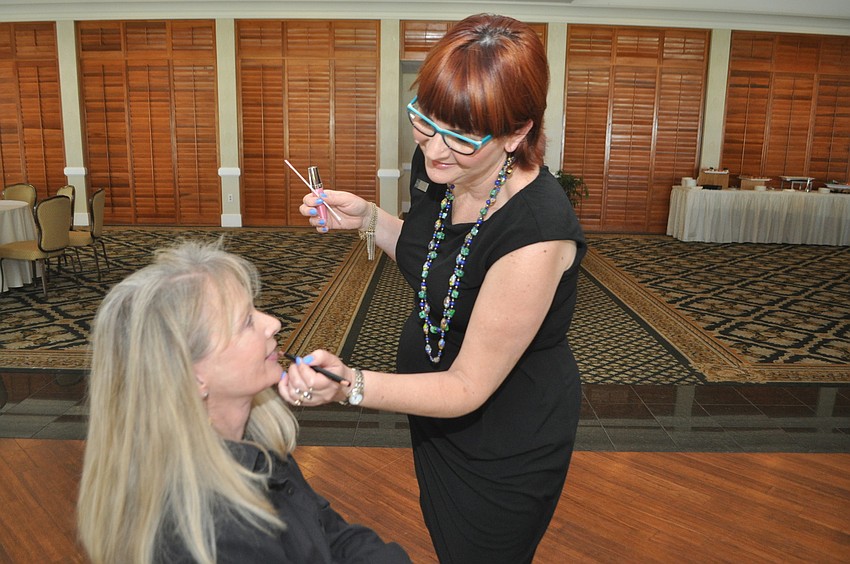 Liz Amberger applies lipstick to Susan Kelley