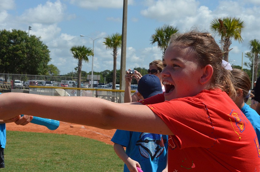 Brianna Raphael plays a game where she must spray water into a bucket her classmate Christian Soloranzo is holding.