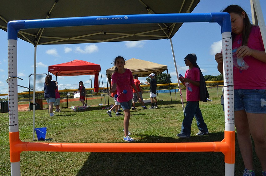 Liz Mullins collects baseball bucks at the ladder game and shows a demonstration on how to play.