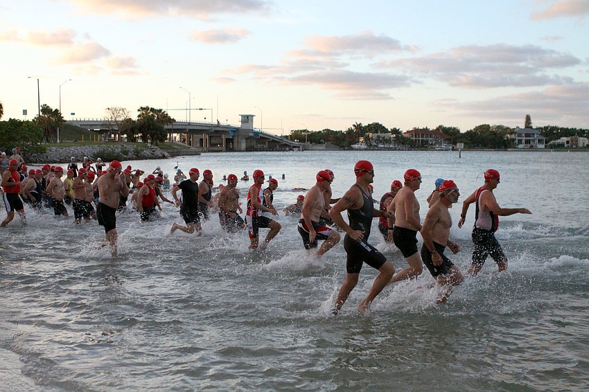 The first group of men head into the water to start off the sprint triathlon.