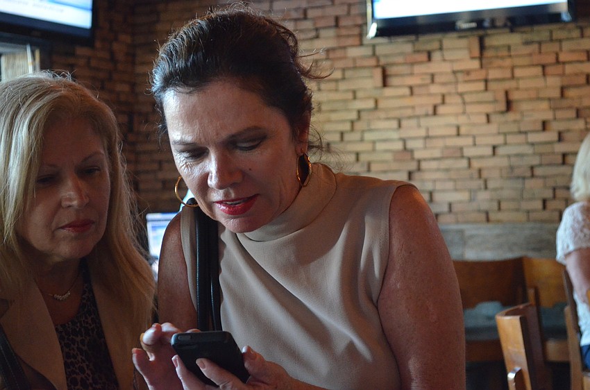 Mayor Suzanne Atwell supporter Nancy Pheehan checks the results of the elections on her phone.
