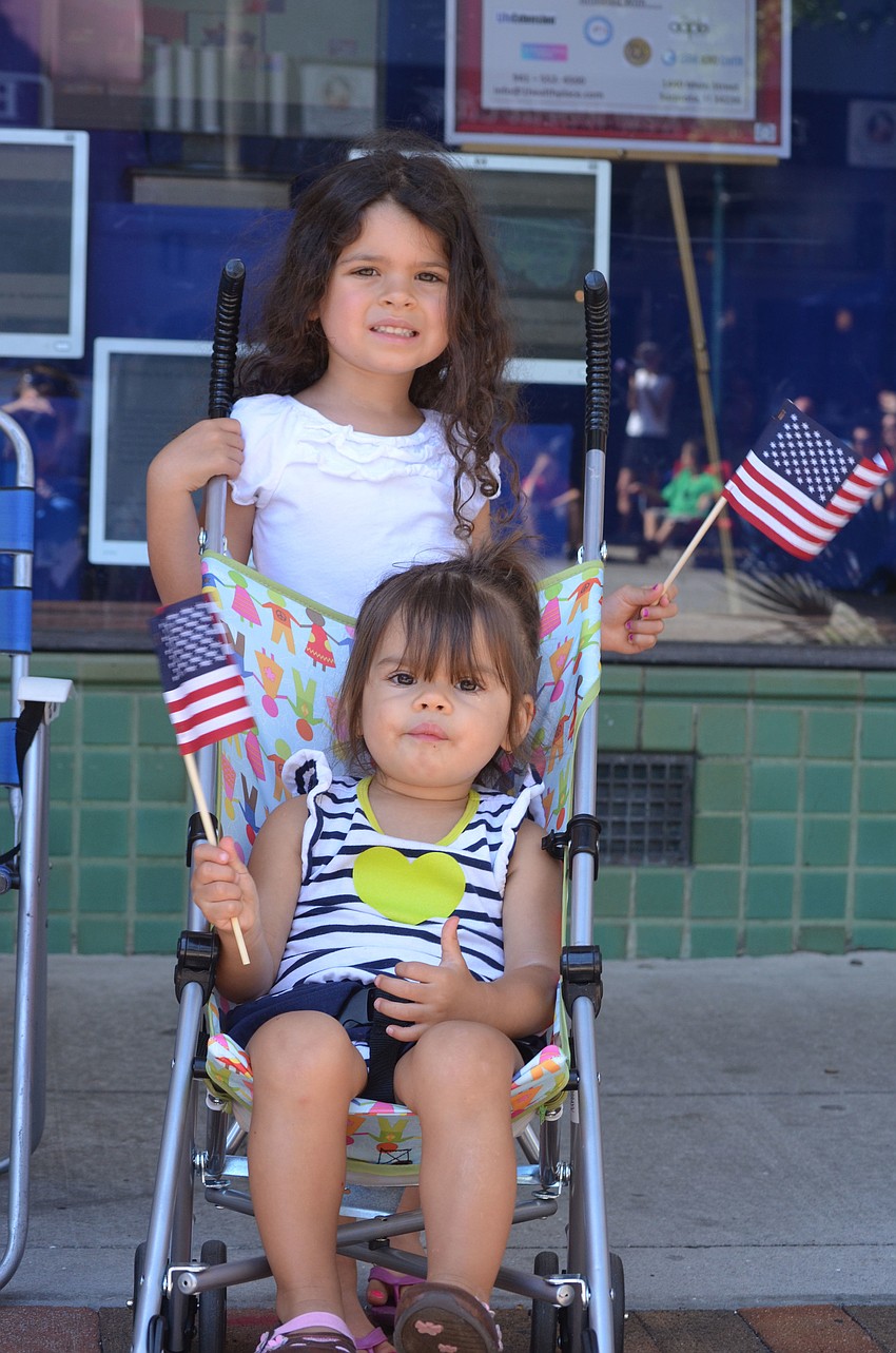 Ashley and Brianna Aular watched the parade and waved their American flags.