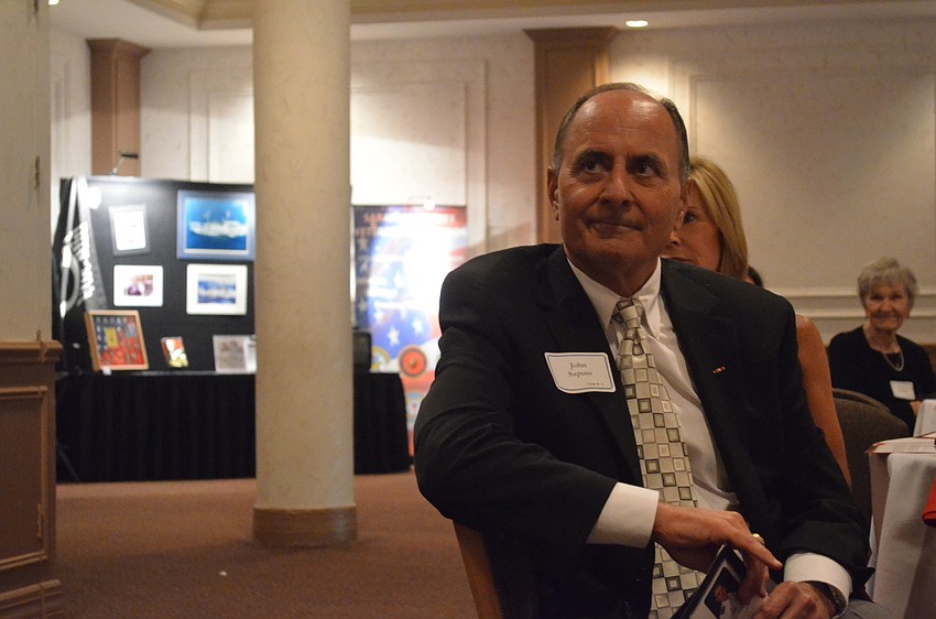 Retired Col. of the United States Marine Corp Reserve John W. Saputo listens to Christopher Reynolds call him to the podium.