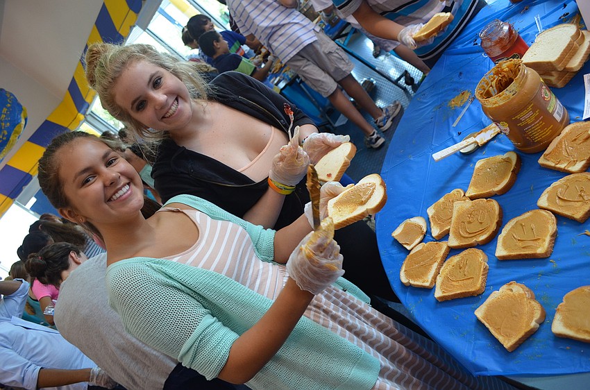 Ninth graders Sofia Quinteros and Lily Desenberg spread soy butter on white bread.