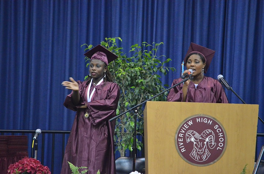 Elexis Ousley signs the National Anthem, as Justine Pedro sings it.