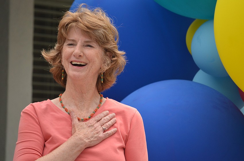 Glendy Huene puts her heart to her hand saying she is touched when the sign unveiling Glendy Huene Library/Media Center was revealed.