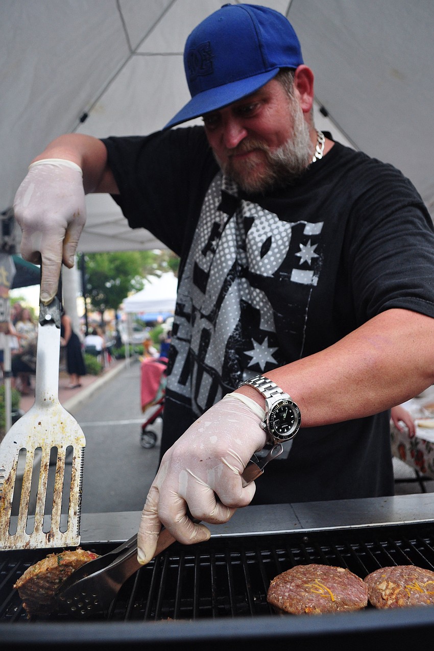 Full Belly Stuffed Burgersâ€™ owner Shane Keinz grills up hamburgers for the crowd.