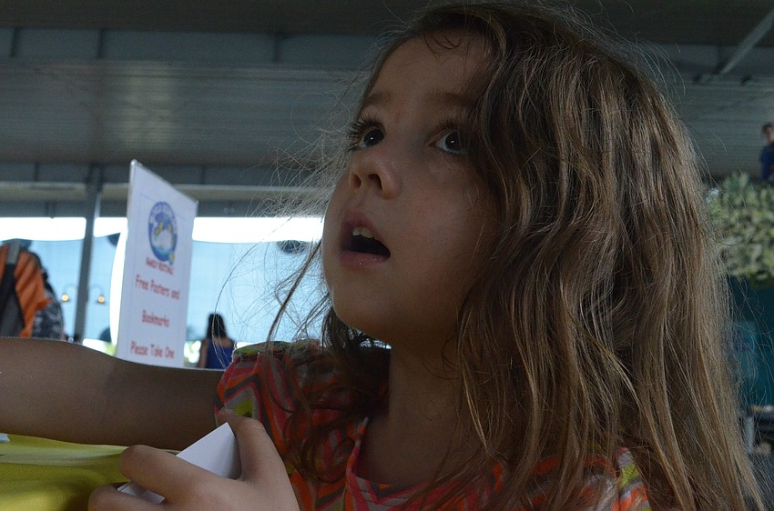 Carlee Lesinski, 3, looks through colorful bookmarks.