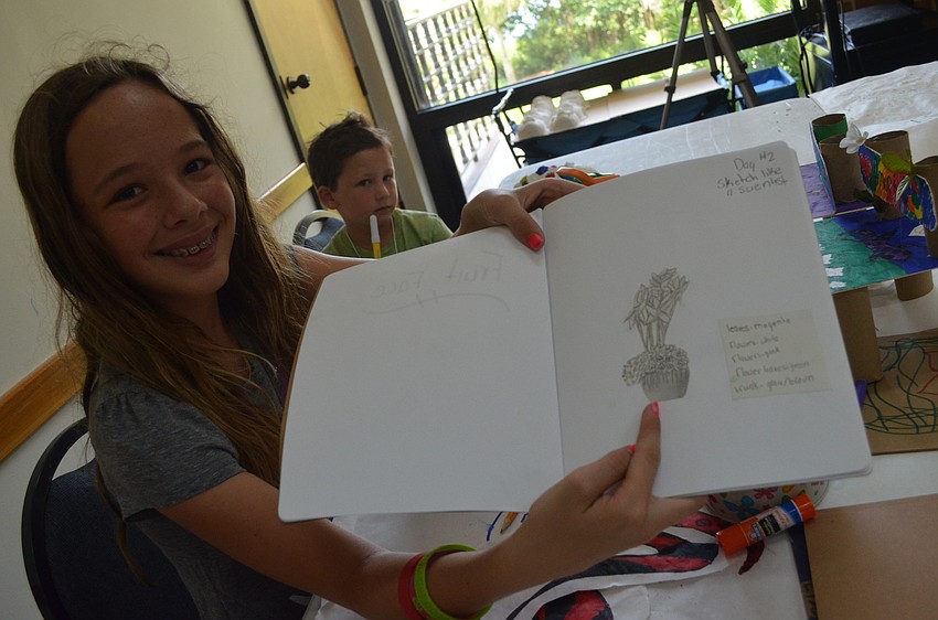 Zoe Nikirk, 12, shows off her flower sketch from the previous day.