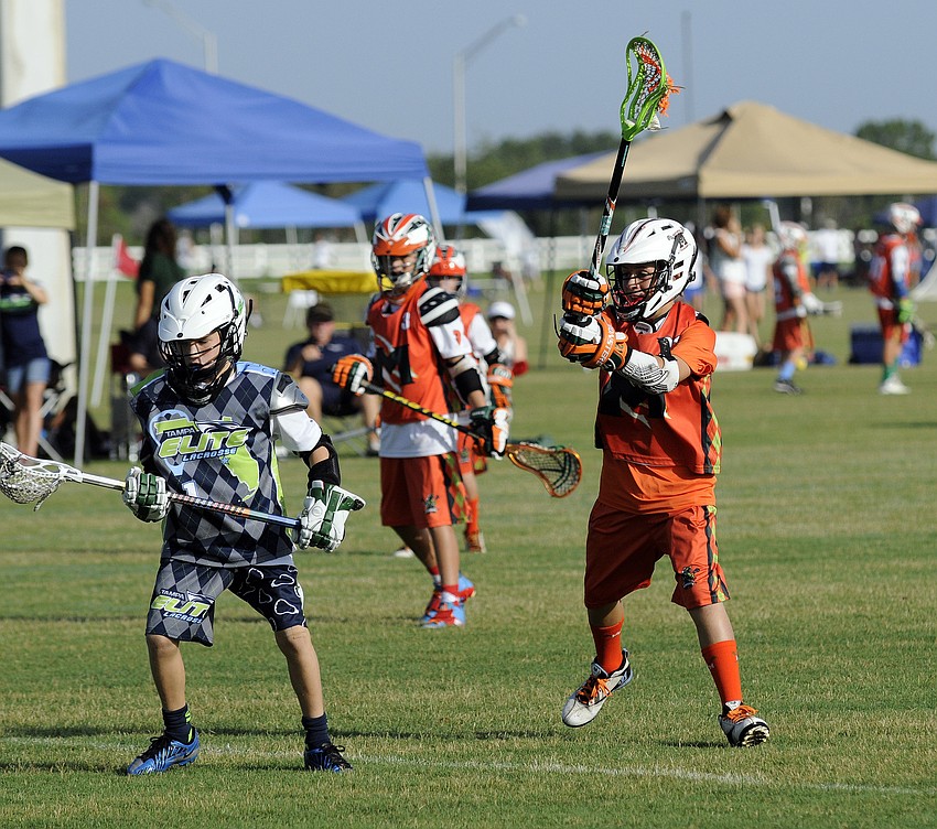 U11 Monsters Orange defender Michael Bavaro, 11, puts his stick in the air in an attempt to thwart a pass.