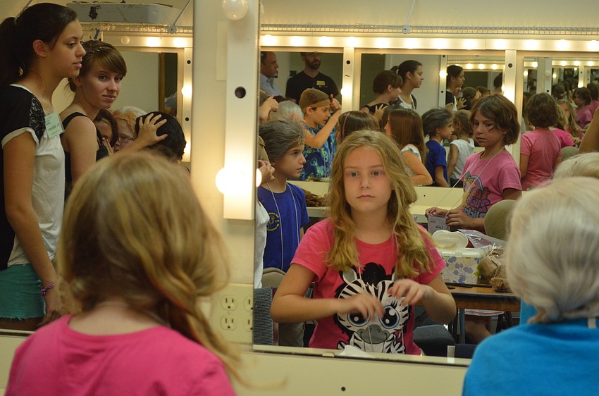 Ashley Spadafora works on her hair after taking of a wig.