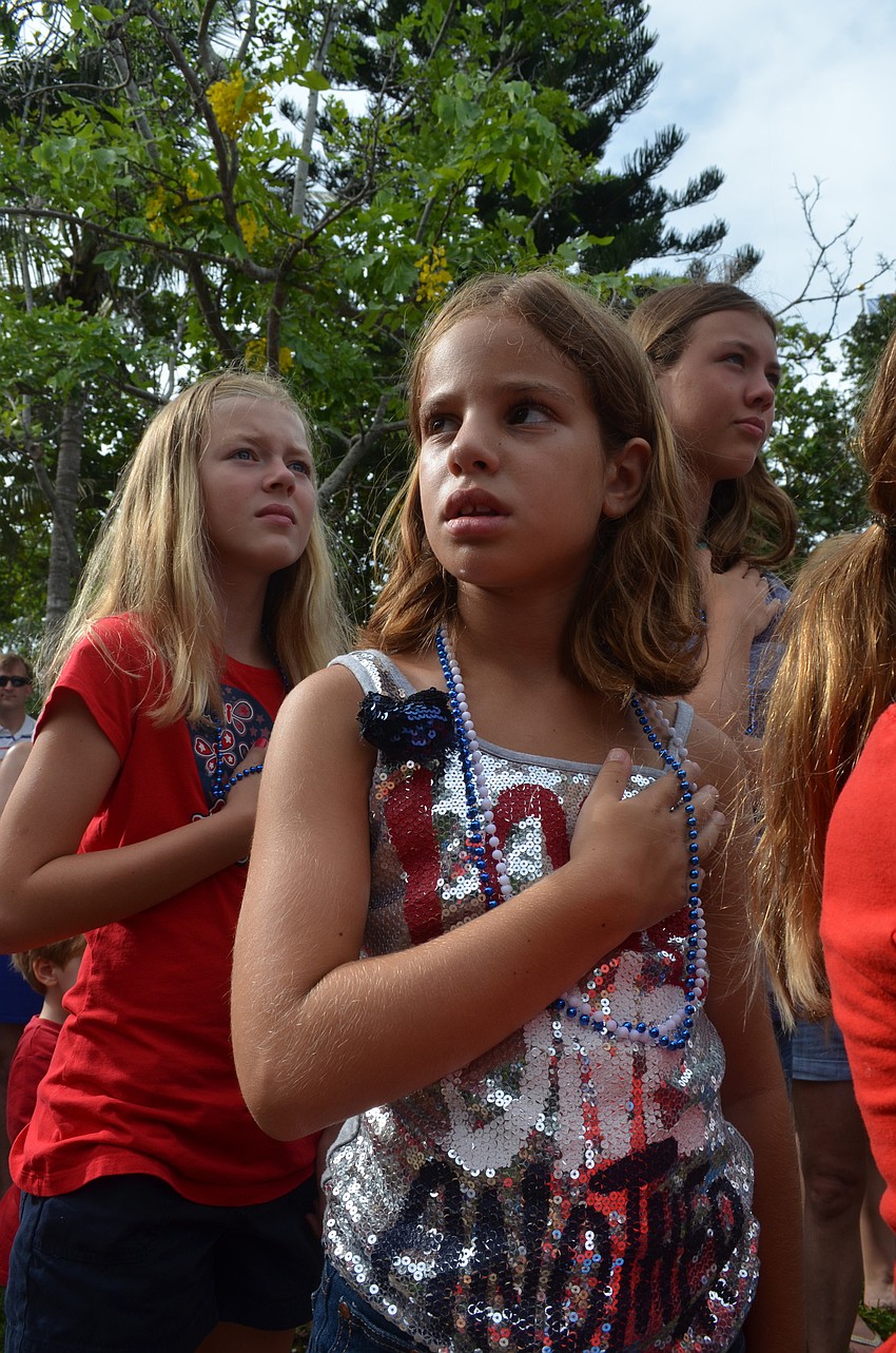 Josie Liederman, 8, watches Mallory Gnaegy sing the national anthem.