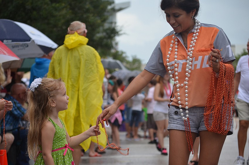 Jessie Undieme represents STHL and gives Emily Garris, 3, beads.