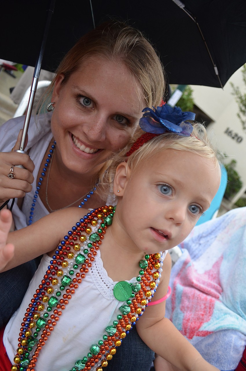 Kelsey Wright watches the parade with her 2-year-old daughter Tayla.