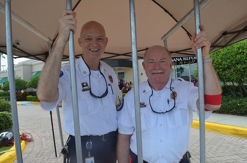 Sarasota County Fire Assistant Chief Rod Van Orsdol and Chief Mike Tobias stay behind a makeshift jail cell during the blood drive.