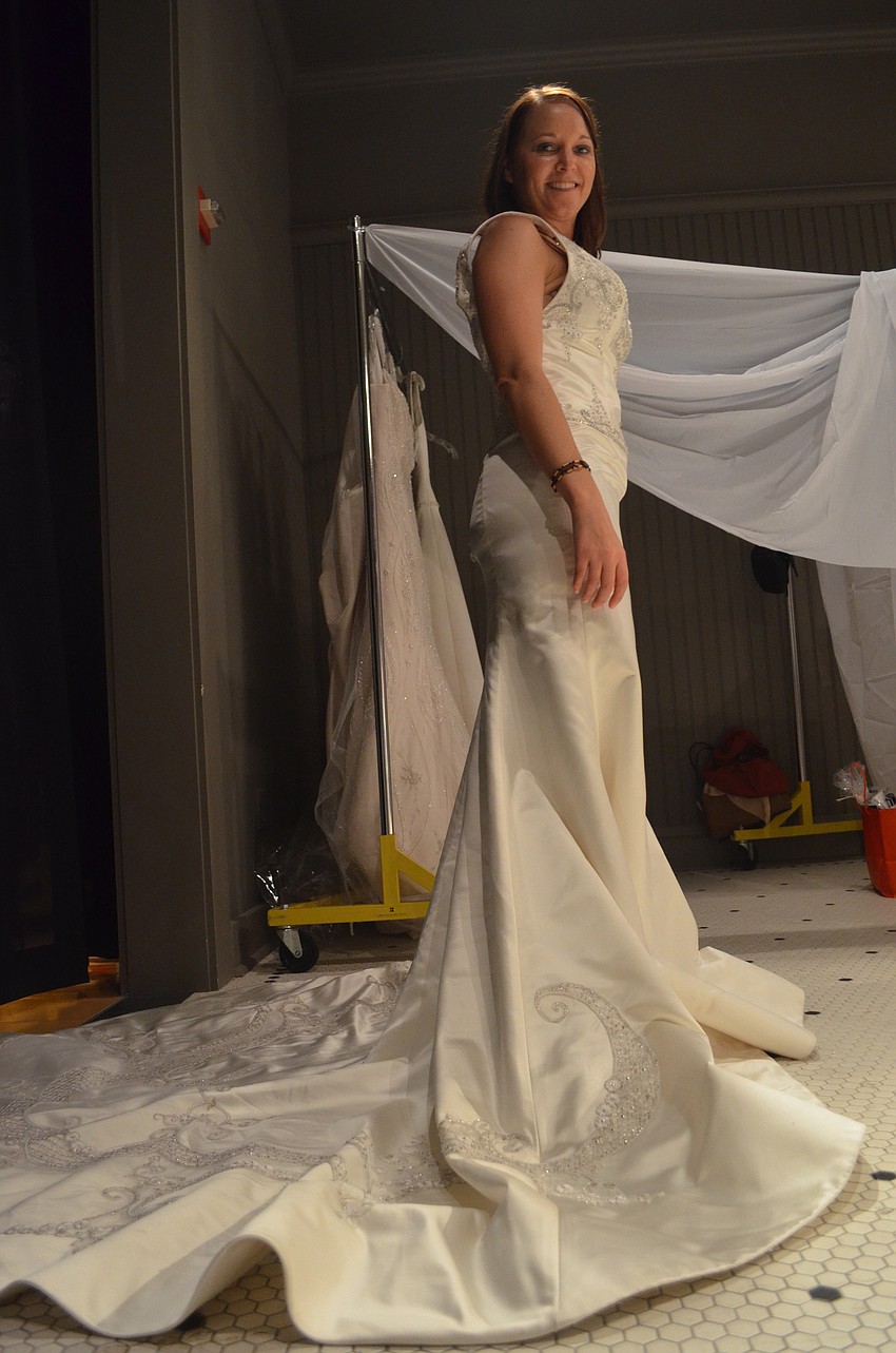 Kristy Lamb tries on her first dress at the bridal show. â€œItâ€™s fun and helps breast cancer, so itâ€™s a win win,â€ Lamb says. She will be married in February of 2014.