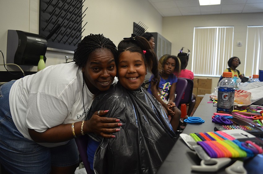 Denise Robins with Eternal Bread of Life Outreach ministries does 10-year-old Tatiana Johnsonâ€™s hair.