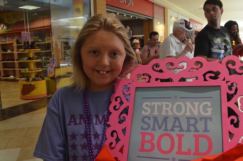 Bailey Brooks wins a framed poster and $25 gift certificate to Westfield Square Mall from the raffle.