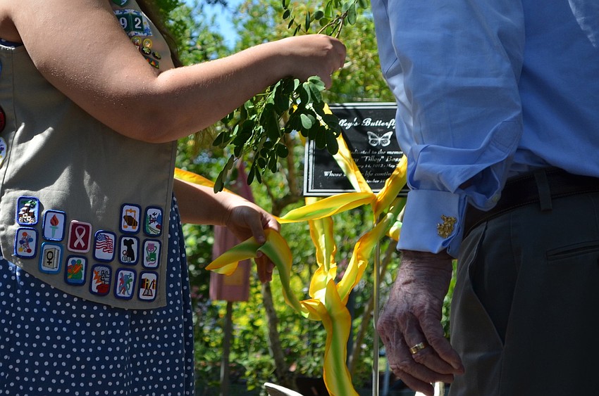 Nichole Peal and Senator Bob Johnson untie the ribbon at the butterfly garden dedication.