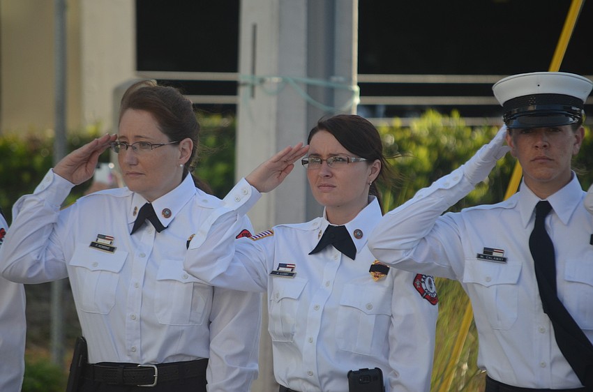 Fire inspectors Florence Robbins and Ashley Lusby and honor guard member Michelle Callaway stand in silence at 8:46 a.m. and 9:03 a.m.