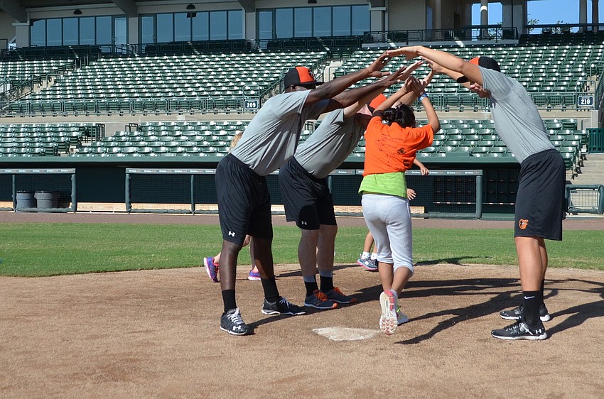Fatima Demiak makes it to home plate and is greeted by players Roderick Bernadina, Kevin Grendell and Matt Price.