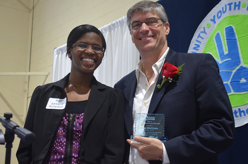 Riverview High School junior Danielle Richardson presents Chef Paul Mattison with a trophy for his work with CYD.