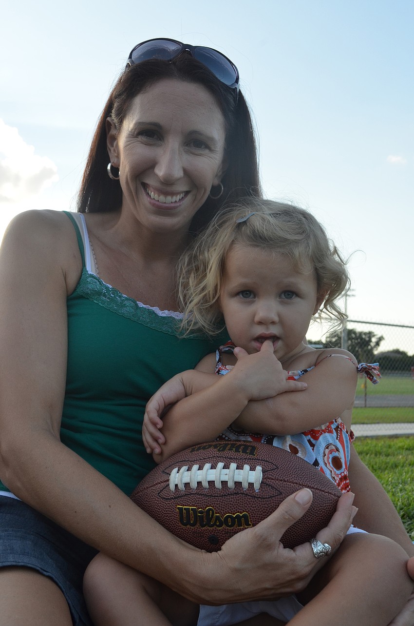 Stephanie McCoy and her daughter Lydia, 2, enjoy some chili for dinner at the tailgate.