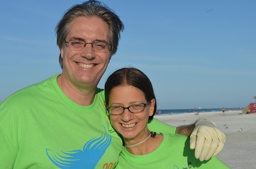 David Sewell and Kathleen Scala clean the beach early Saturday morning.