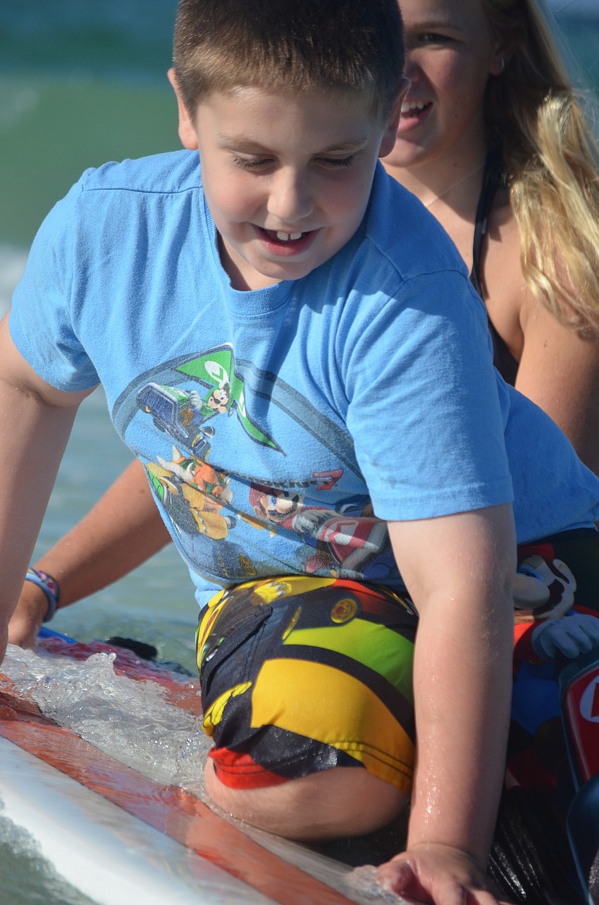 McCleod, 16, helps Ethan Isom, 7, get on the board.