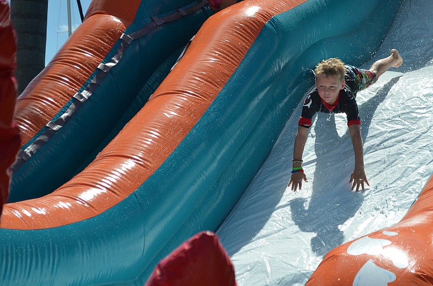 Jack Foluig gets some air going down the water slide at Sarasota Yacht Clubâ€™s Family Fun Fest.